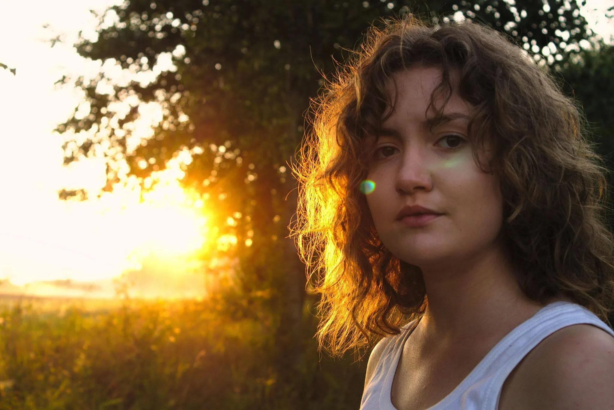 An actress in front of a setting sun